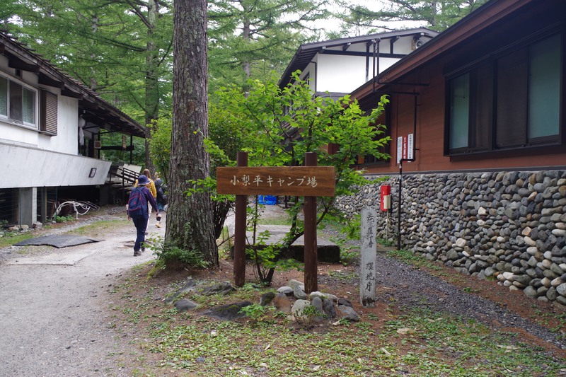 a sign for Konashidaira campground between two buildings